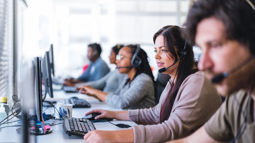 Businesswoman wearing headset and working at computer